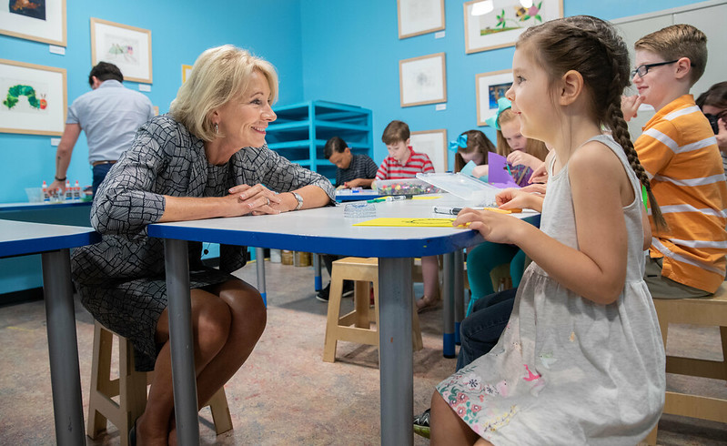 Betsy DeVos visits with a student at a home school event in Jackson, MA.