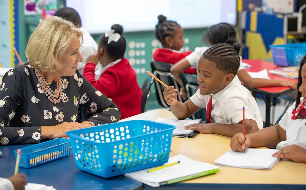 Betsy DeVos listens to a student at Detroit Edison Charter School.
