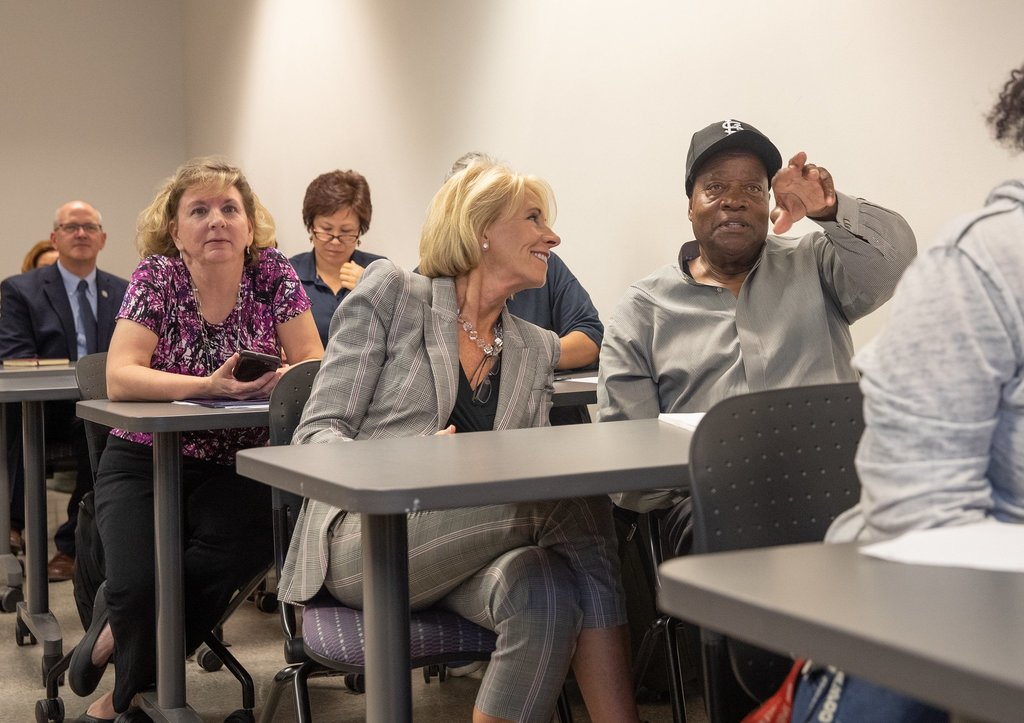 Betsy DeVos visits with adults participating in a lifelong learning program at Montgomery Community College